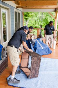 Gasperson mover preparing to wrap up patio furniture at a residential home