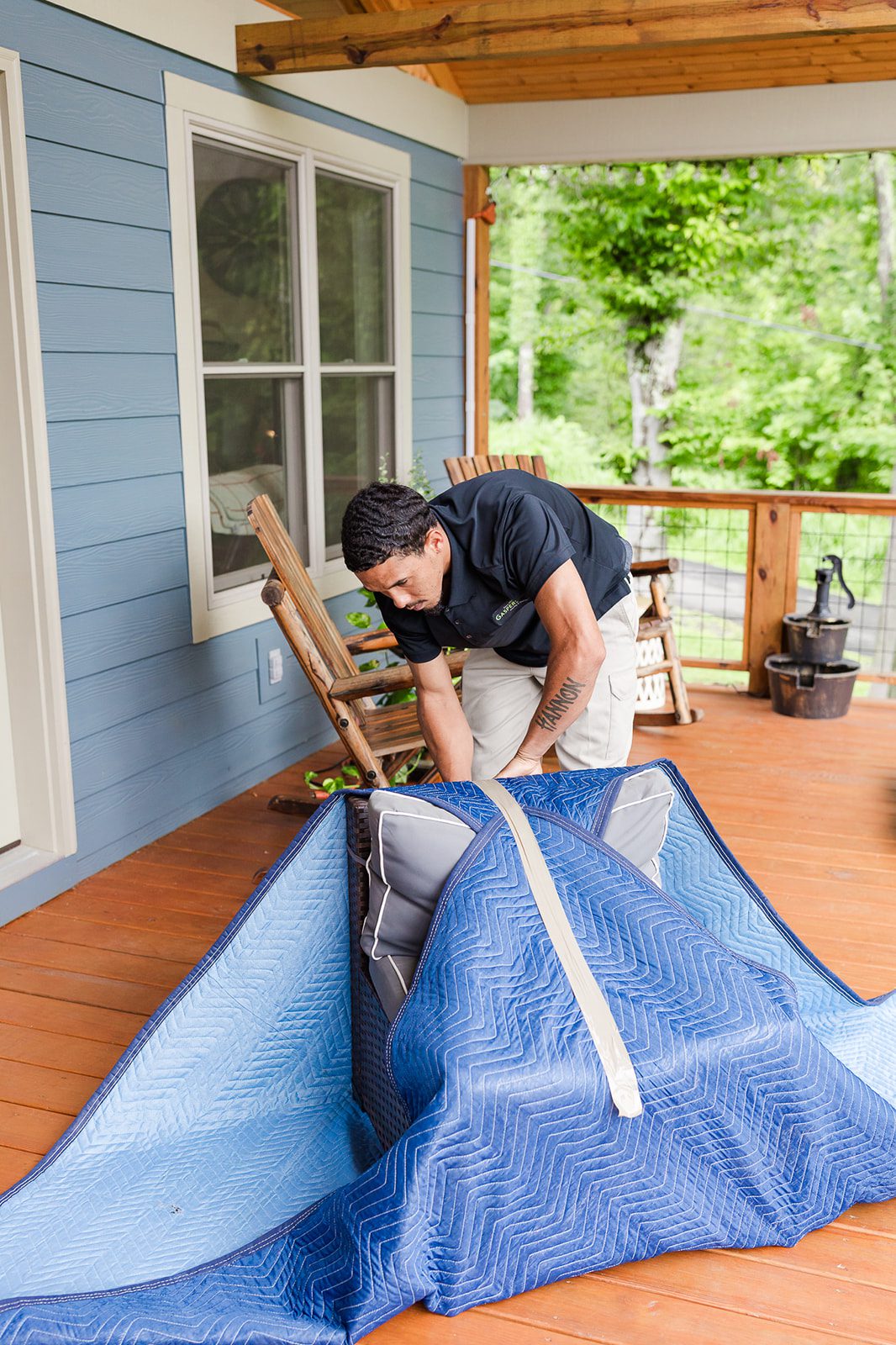 Gasperson mover carefully wrapping up an outdoor chair on a residential patio