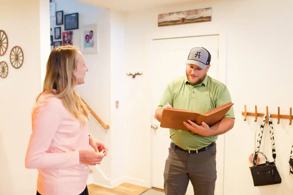 Gasperson mover taking notes while inspecting residential home with resident